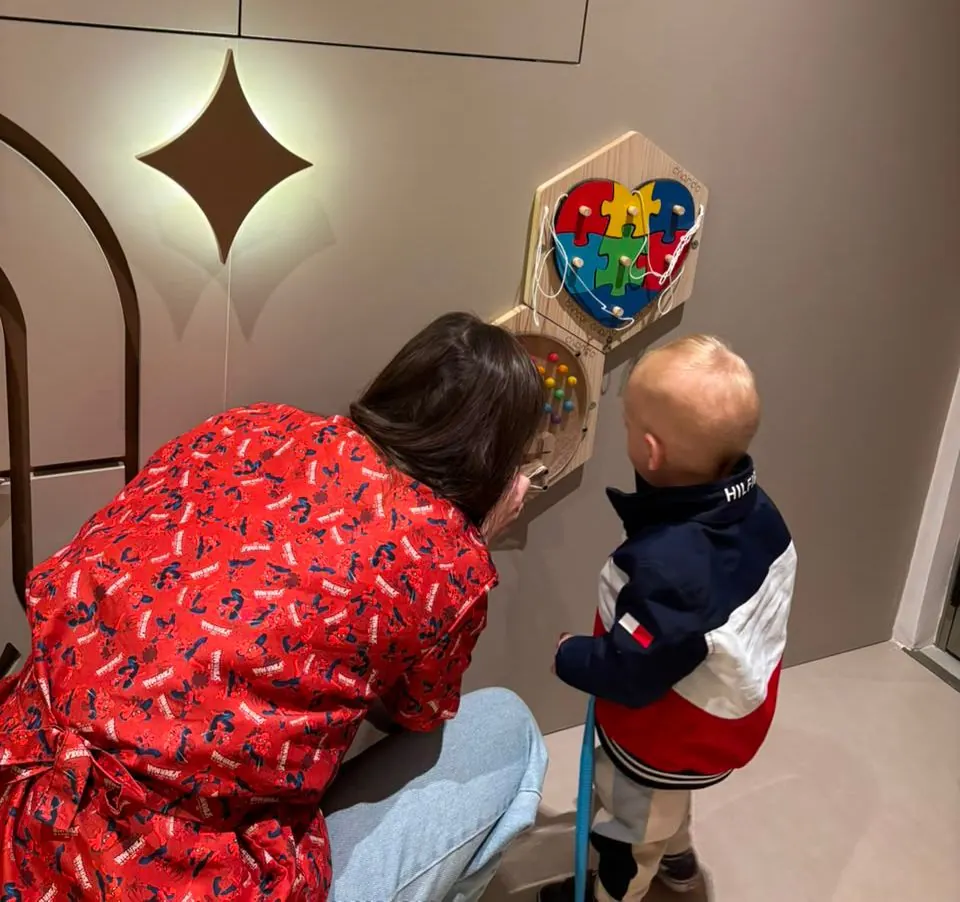Criança brincando no painel sensorial da sala de espera
