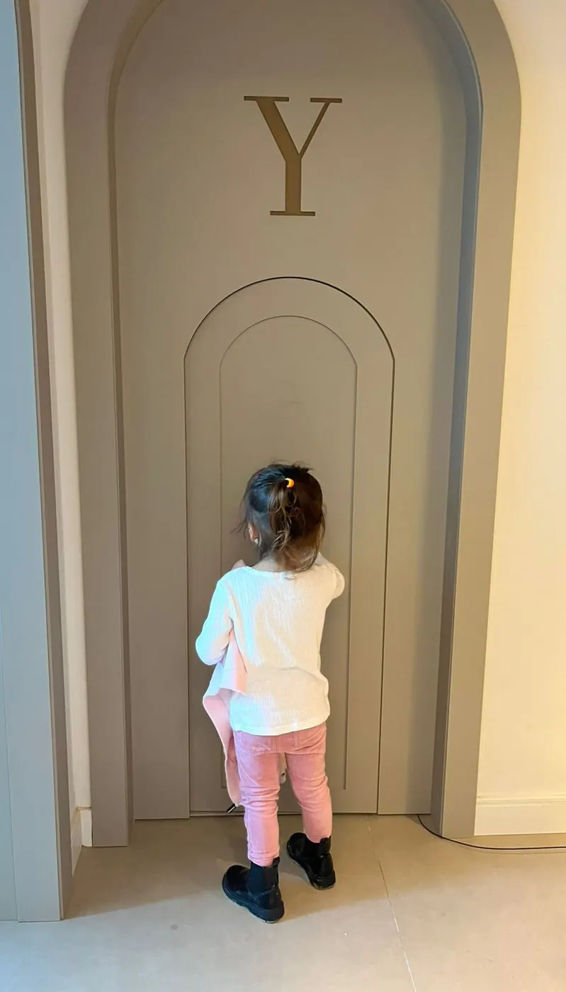 Criança explorando a portinha lúdica da recepção da Lyòra